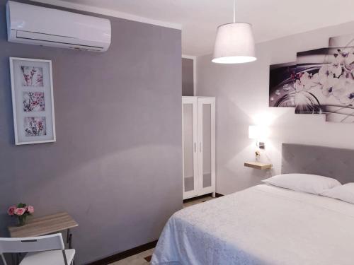 a bedroom with a white bed and a lamp at Villa Rosa in Agropoli