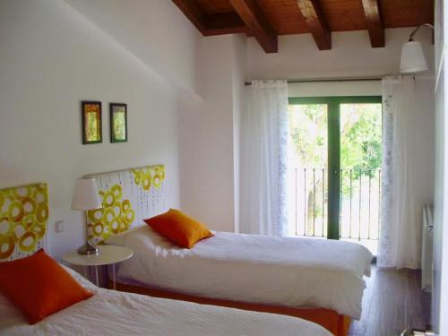 a bedroom with two beds and a window at Casa los Tres Nogales in Castroserna de Arriba