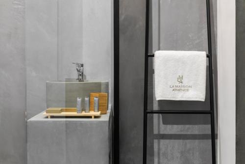 a bathroom with a sink and a towel at La Maison Athenes in Athens