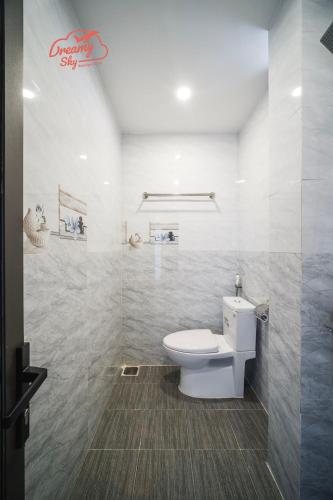 a bathroom with a white toilet and a shower at Dreamy Sky - Airport View Boutique Hotel in Da Nang