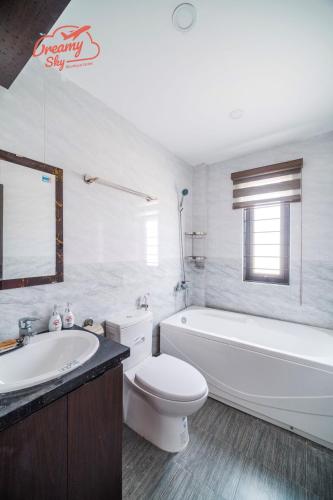 a bathroom with a tub and a toilet and a sink at Dreamy Sky - Airport View Boutique Hotel in Da Nang