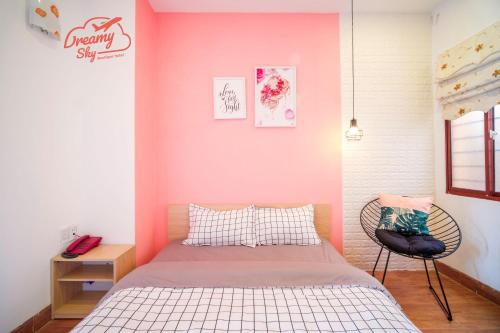 a bedroom with a bed and a pink wall at Dreamy Sky - Airport View Boutique Hotel in Da Nang