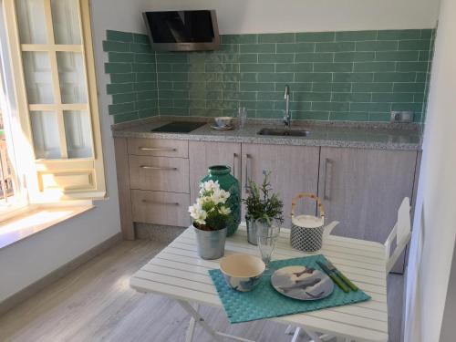 a small kitchen with a table with flowers on it at NATURA SUITE MÁLAGA in Málaga