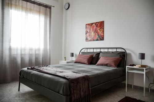 a bedroom with a bed and a window at Casa Pomelia in Castellammare del Golfo