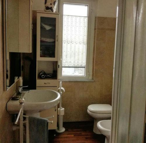 a bathroom with a sink and a toilet and a window at 100 Viale Italia in La Spezia