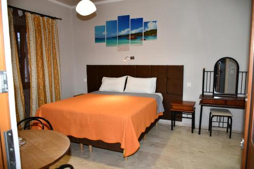 a bedroom with a bed with an orange blanket and a piano at Seaview in Agios Georgios
