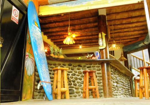 a room with a bar with two surfboards and stools at La Facha Hostal Restaurant Surf in Mompiche
