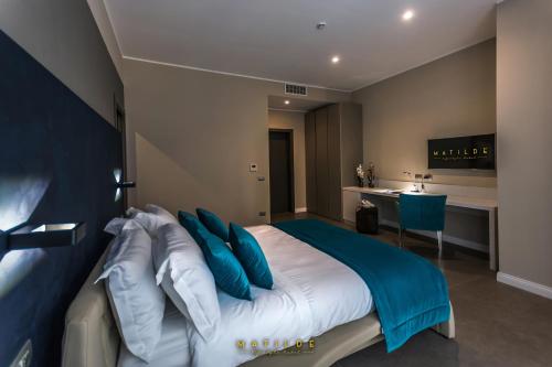 ナポリにあるHotel Matilde - Lifestyle Hotelのベッドルーム1室(青と白の枕が備わるベッド1台付)