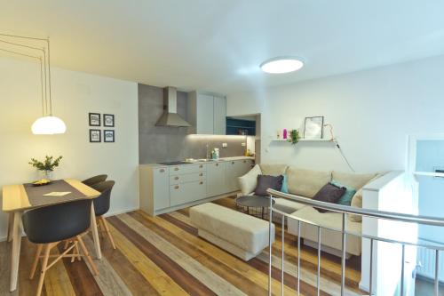 a kitchen and living room with a couch and a table at City Centre Apartments in Ljubljana