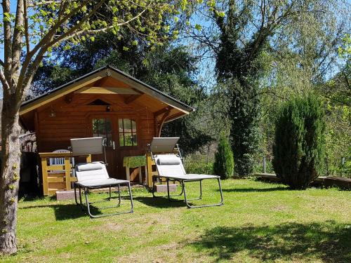 two chairs and a table in front of a cabin at Höllenbergblick in Spirkelbach