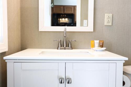 a bathroom with a white sink and a mirror at Grand Hotel Cape May in Cape May