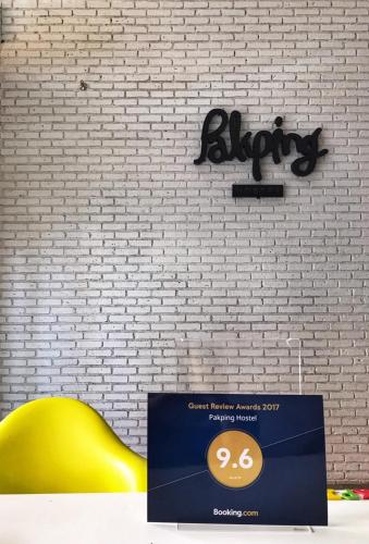 a yellow chair sitting in front of a white brick wall at Pakping Hostel in Chiang Mai