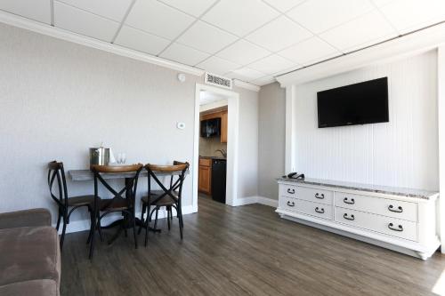 a living room with a table and a television on a wall at Grand Hotel Cape May in Cape May