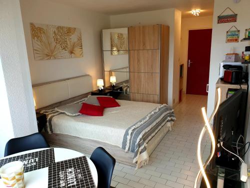 - une chambre avec un lit doté d'oreillers rouges dans l'établissement Studio Port Vénus Village Naturiste, au Cap d'Agde