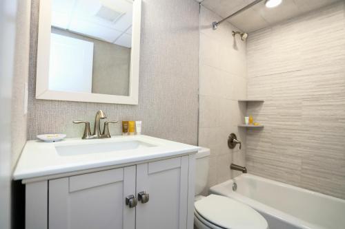 a bathroom with a sink and a toilet and a mirror at Grand Hotel Cape May in Cape May
