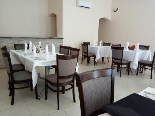 a dining room with white tables and chairs at Wadonda Suites in Zomba