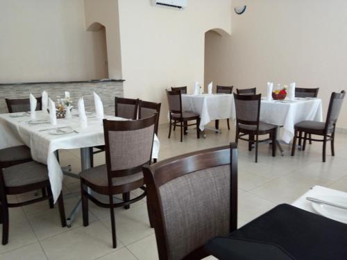 a dining room with white tables and chairs at Wadonda Suites in Zomba