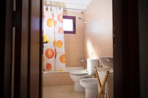 a bathroom with a toilet and a shower curtain at La Casa Sahi in Gáldar