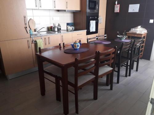 a kitchen with a wooden table and chairs in a kitchen at Pés Verdes-Alojamento e Chá in Ponta Delgada
