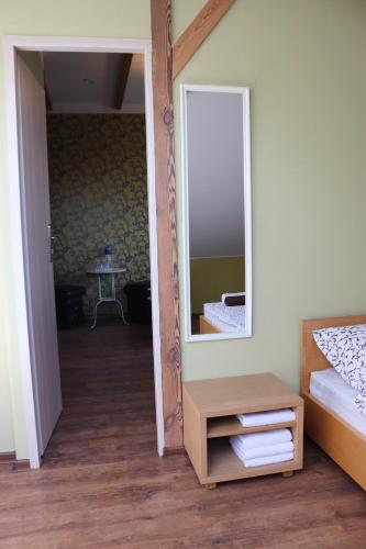 a bedroom with a mirror and a bed and a table at Pozingė Pegasas Pokylių namai in Klaipėda