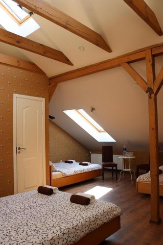 a attic room with two beds and two skylights at Pozingė Pegasas Pokylių namai in Klaipėda
