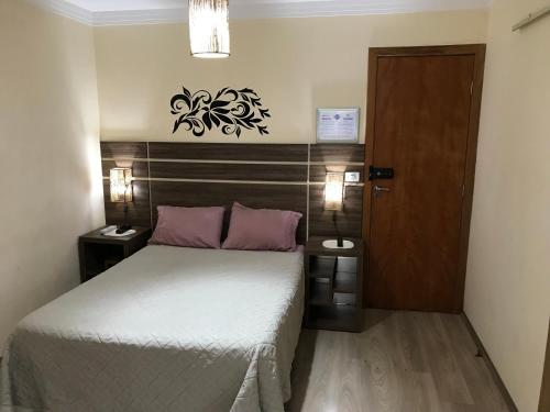 - une petite chambre avec un lit et une porte en bois dans l'établissement GA1-Hospedagem Próximo ao Aeroporto de Guarulhos, à Guarulhos