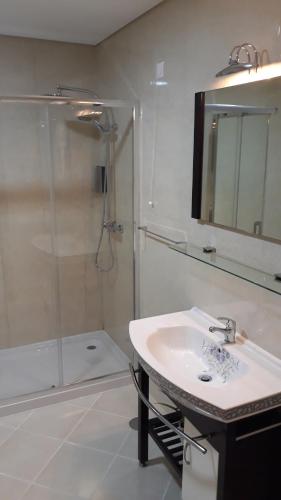 a bathroom with a shower and a sink and a mirror at Cidadelhe Rupestre Turismo Rural in Cidadelhe