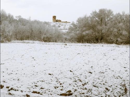 a field covered in snow with a building in the background at Las Casonas de Chavida in Chavida