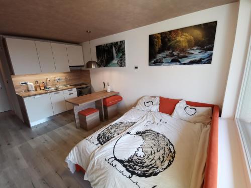 um pequeno quarto com uma cama e uma cozinha em Studio Apartment Jež em Bovec