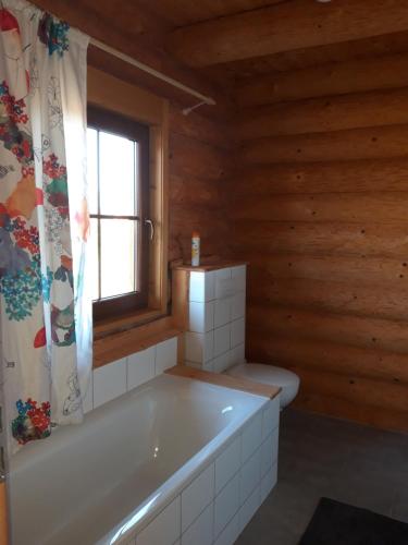 a bathroom with a bath tub and a window at Jafura LM in Liptovský Trnovec