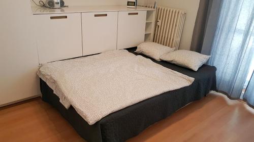 łóżko z białą szafką i 2 poduszkami w obiekcie City Lights Apartment with Terrace - 24 Hours Check in w Bratysławie