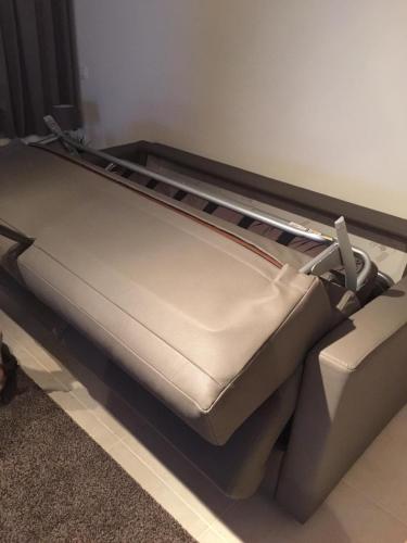 a bed in a room next to a couch at Les terrasses de Malmédy in Malmedy