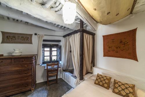 a bedroom with a bed and a dresser and a window at Casa Nicolasa in Capileira