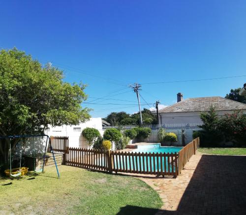 a fence around a swimming pool in a yard at Coons Cove in Cape Town