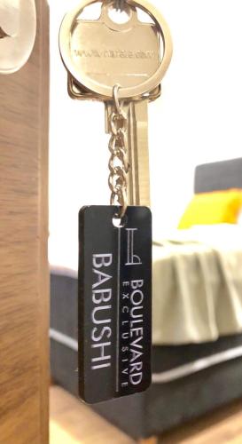 a key chain with a book on a bed at Boulevard Exclusive in Pristina