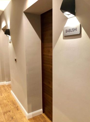 a hallway with a door with a sign that reads baudisel at Boulevard Exclusive in Pristina