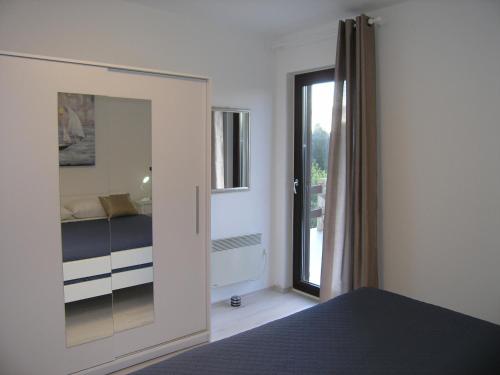 ein Schlafzimmer mit einem Bett und eine Tür mit einem Fenster in der Unterkunft Vlasta in Mali Lošinj