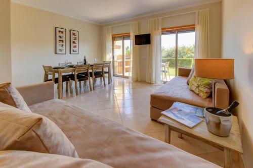 a living room with a couch and a table at Pinheiros da Balaia Villas in Albufeira