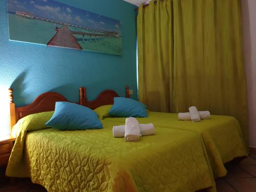a bedroom with two beds with towels on them at Pension los Verdiales in La Herradura