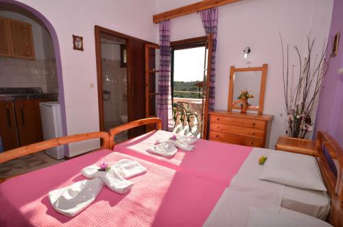 帕萊歐卡斯提撒的住宿－Lisipio Studios by Eleni，一间设有一张桌子的房间,配有粉色和白色的桌布