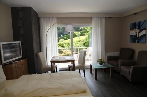 a bedroom with a bed and a living room with a window at Appartementhaus Vierjahreszeiten in Willingen