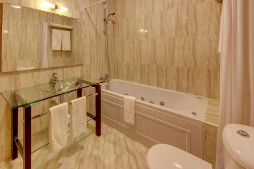 łazienka z wanną, umywalką i toaletą w obiekcie Pinheiros da Balaia Villas w Albufeirze