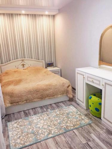 Schlafzimmer mit einem Bett, einem Spiegel und einem Teppich in der Unterkunft Двухкімнатна студія in Tschernihiw