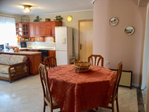 a kitchen with a table with a red table cloth at Mikro Katafygio in Stávloi