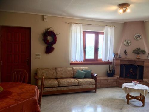 a living room with a couch and a fireplace at Mikro Katafygio in Stávloi