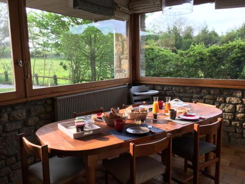 Cette chambre dispose d'une table en bois et d'une grande fenêtre. dans l'établissement LA CHAMADE, à Carolles