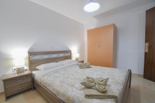 a bedroom with a large bed with towels on it at The Olive Garden House in Haraki