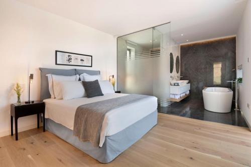 a bedroom with a bed and a bathroom with a tub at Elea Silver Villa in Peyia