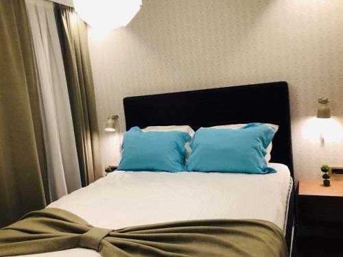 a bedroom with a bed with blue pillows at Boulevard Exclusive in Pristina