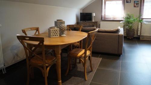 a dining room table with chairs and a couch at Guesthouse Biolleke in Boutersem
